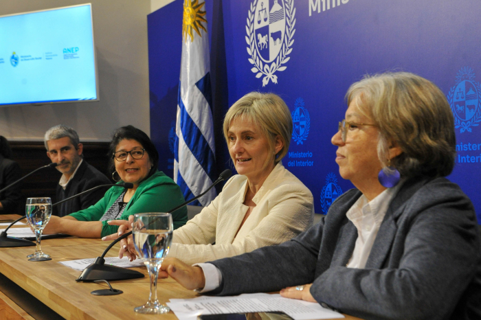 Autoridades exponen en mesa con micrófonos
