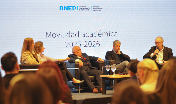 Autoridades sentadas en sillones negros en el escenario de la sala de Antel 
