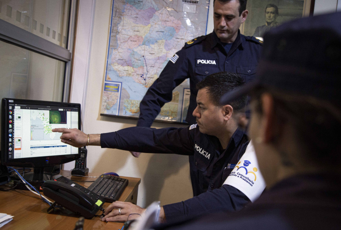Un policía apunta hacia la pantalla de una computadora, mostrando información