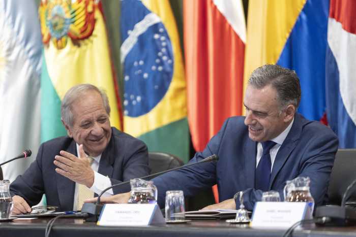 Presidente Orsi y secretario general de Aladi sonrientes sentados en mesa con micrófonos.
