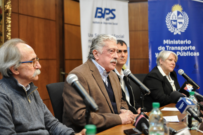 Director de BPS diserta sentado en mesa con micrófono junto a otros tres participantes.