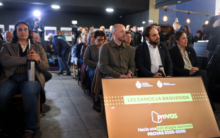 Titular de Desarrollo Social y ministra de Industria sentados, con público a su alrededor. 