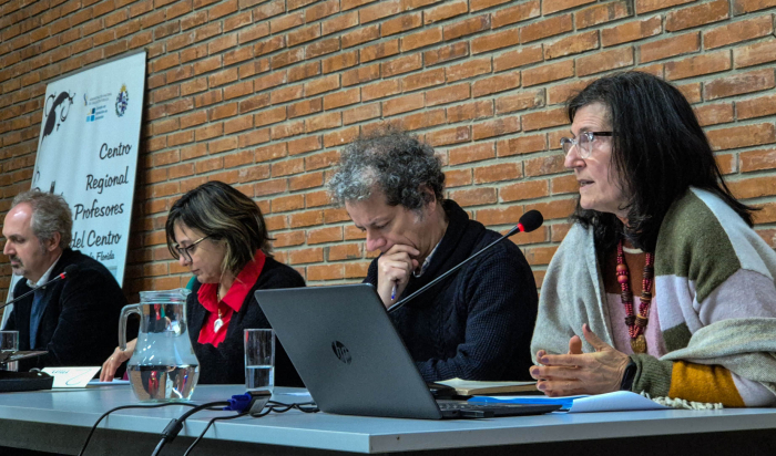 Cuatro investigadores sentados en una mesa con micrófonos disertan
