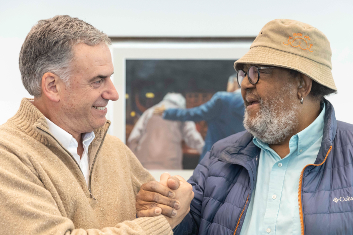 Presidente Orsi y el músico Rubén Rada se saludan sonrientes con un apretón de manos en el despacho.