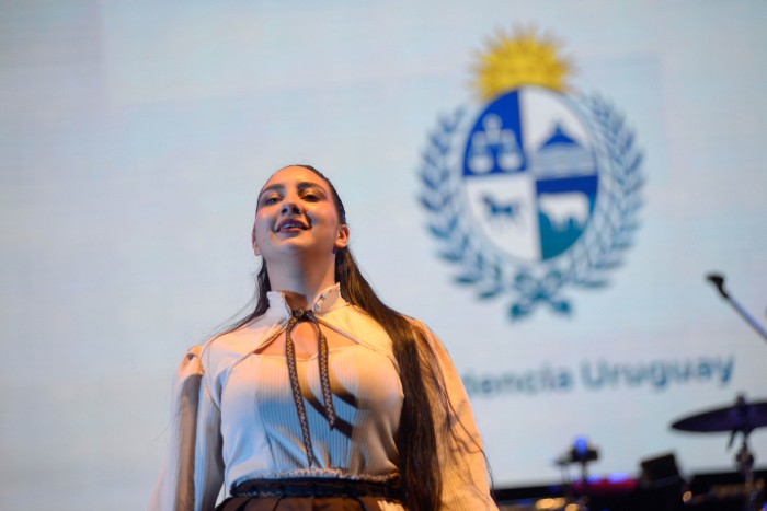Primer plano de mujer vestida con ropas tradicionales en el escenario. 
