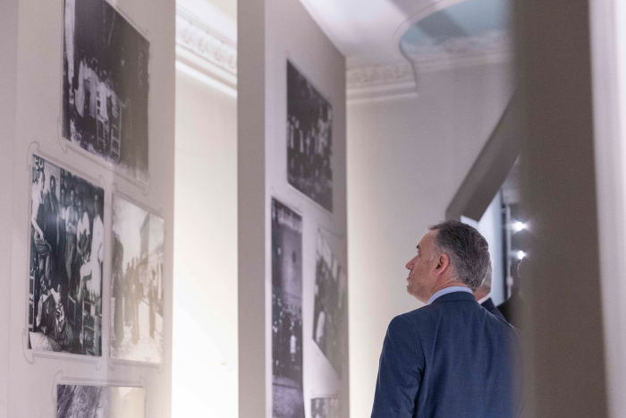 Orsi de espaldas contempla fotografías históricas en blanco y negro 