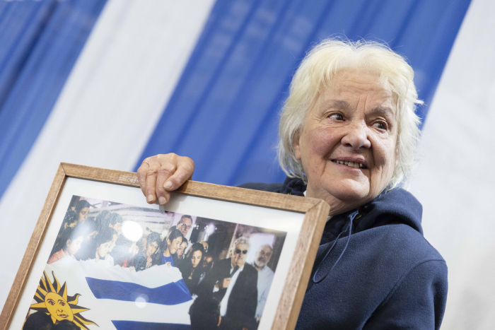 Primer plano de Lucía Topolansky sosteniendo una foto enmarcada de José Mujica 