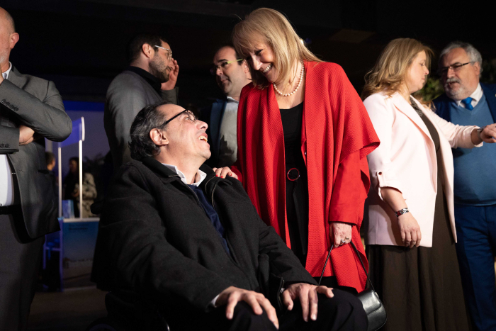 Cosse dialoga con el ministro de Turismo en un salón de eventos.