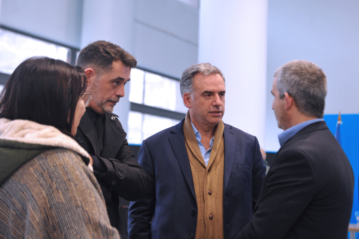 Orsi, parado, dialoga con el presidente de la ANEP.