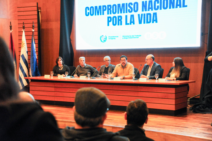 Secretario de la Presidencia, junto a otras autoridades sentado en una mesa en escenario .
