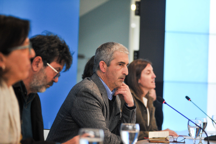 Presidente de la ANEP sentado en mesa con micrófono junto a otras autoridades 