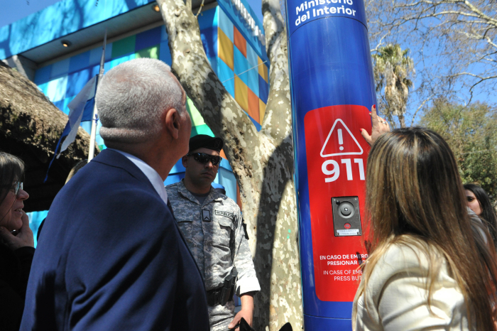 Ministro del Interior, de espaldas, junto a una mujer observa un tótem 