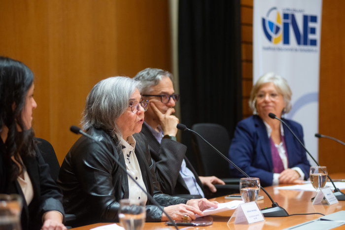 Subdirectora del INE diserta sentada en mesa con micrófono junto a otras autoridades 