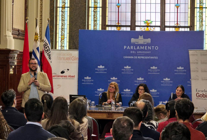 Integrante del equipo técnico de la Contaduría Nacional de la Nación diserta de pie con micrófono en