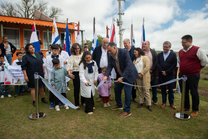 Orsi corta cinta de inauguración de obras de electrificación con varios niños y autoridades de UTE.
