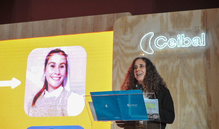 Presidenta de Ceibal diserta de pie en atril, con micrófono en mano.