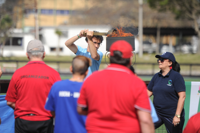 Un joven enciende un pebetero con una antorcha para dar inicio a los Juegos