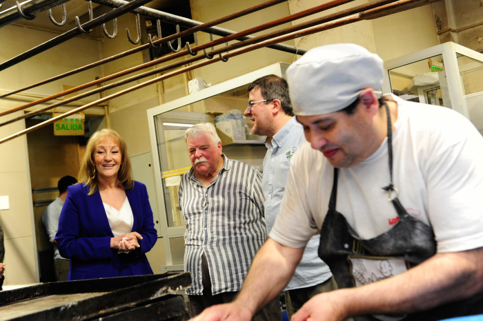 Cosse sonriente conversa con los dueños de la panadería Los Tíos.