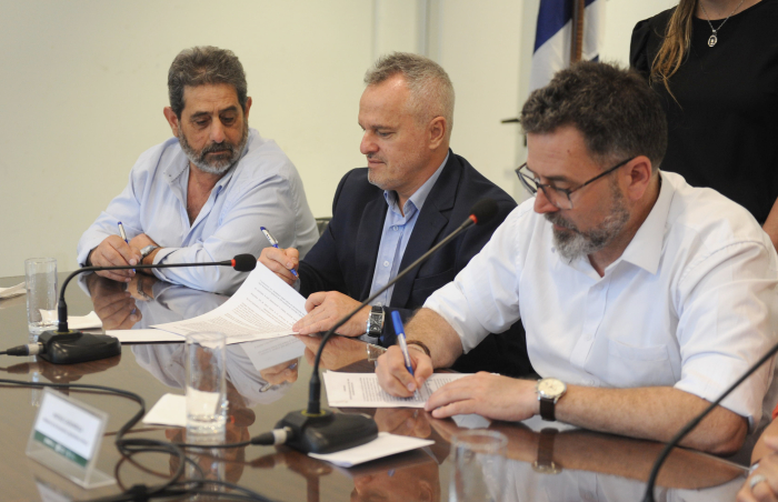 Ministro interino de Ganadería junto a las autoridades de la UAM firman documentos sobre una mesa.