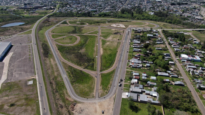 Vista aérea de un área de terrenos con caminos pavimentados, senderos de tierra y casas