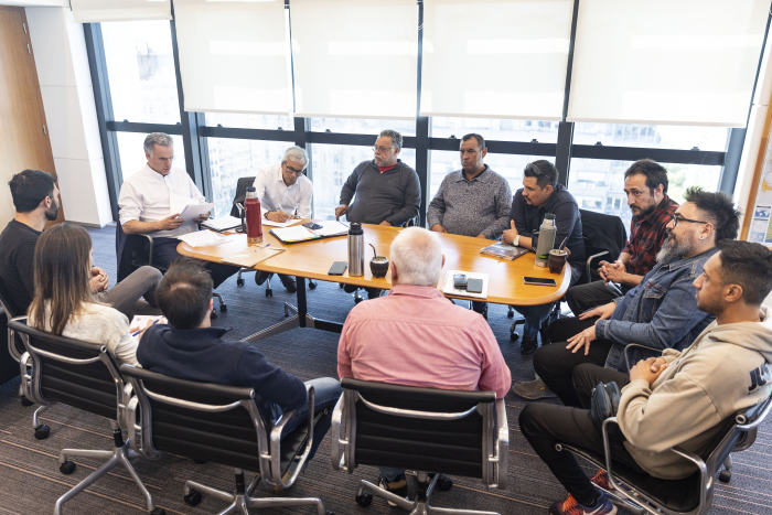 Orsi de espaldas dialoga con representantes del sindicato de Conaprole.