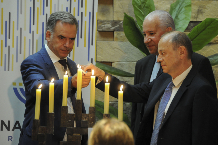 Orsi enciende una vela junto al presidente de B´nai B´rith Uruguay y Ruperto Long.