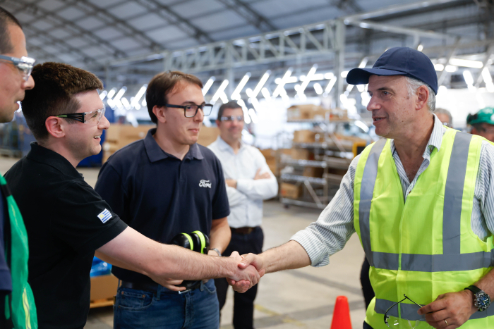 Orsi abraza afectuosamente a un directivo de la empresa Nordex, en el ingreso a la planta