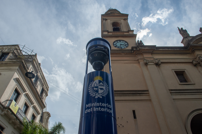 Primer plano del tótem azul del Ministerio del Interior colocado frente de la catedral de Montevideo