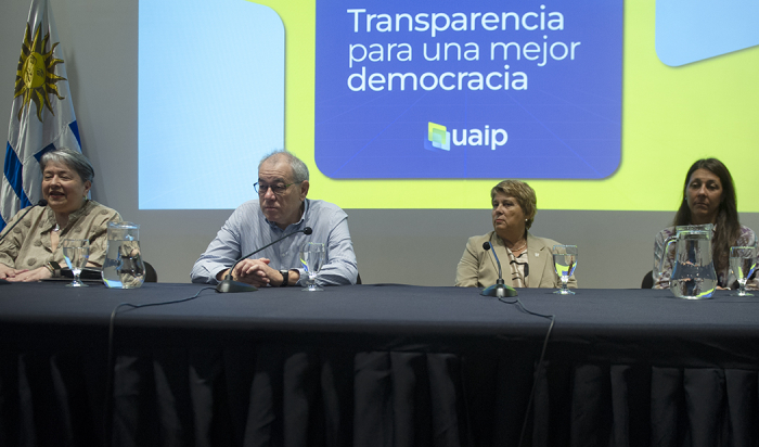 Director Ejecutivo de Agesic junto a tres autoridades más sentado en mesa con micrófonos 