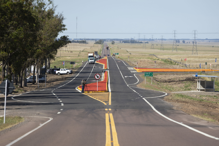 Plano general de una carretera con una bifurcación y un cruce, con vehículos y árboles
