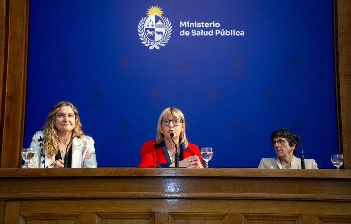Ministra de Salud Pública diserta sentada en mesa con micrófono.