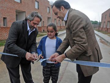 Corte de cinta realizado por autoridades de Vivienda y una niña