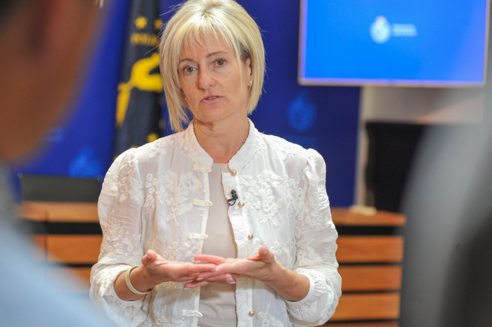 Subsecretaria del Ministerio del Interior, de pie, dialoga con periodista