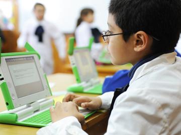 Niño con computadora del Plan Ceibal