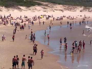 Playa con personas bañándose Playa con personas bañándose