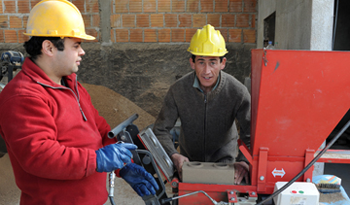 Trabajadores fabricando bloques para industrias de la construcción