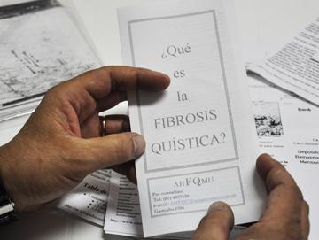 Manos de personas con un folleto informativo de la enfermedad