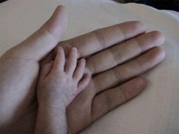 Mano de bebe y de adulto tocandose
