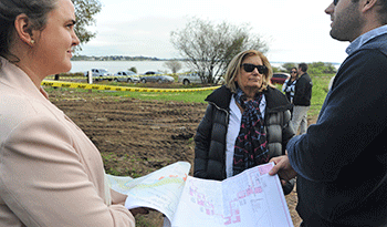 Ministra Eneida de León junto a arquitectos observan planos del nuevo proyecto para la zona inundable frente al río Uruguay