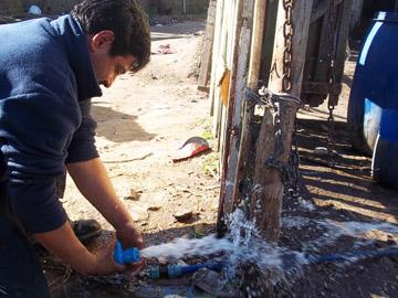 Funcionario de OSE realiza conexión de agua