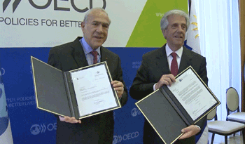 Tabaré Vázquez muestra el acta de ingreso de Uruguay como observador en el Centro de Desarrollo de la OCDE