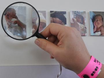 Mano que muestra a través de una lupa las fotos de niños
