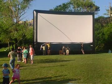 Personas colocan una pantalla para ver cine al aire libre