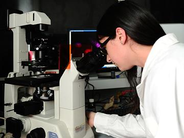 Profesional mirando por un microscopio