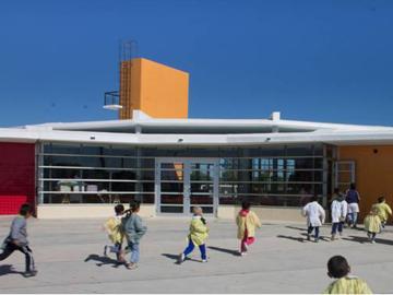 Fachada de la escuela con niños corriendo