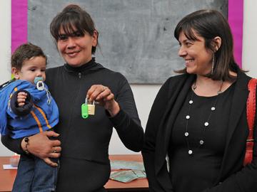Madre con su hijo recibiendo las llaves de parte de la autoridad