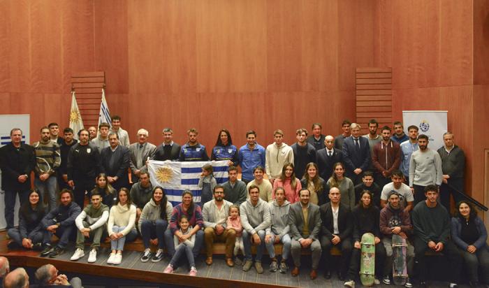 Foto grupal de todos los deportistas que reciben el pabellón nacional junto a las autoridades 