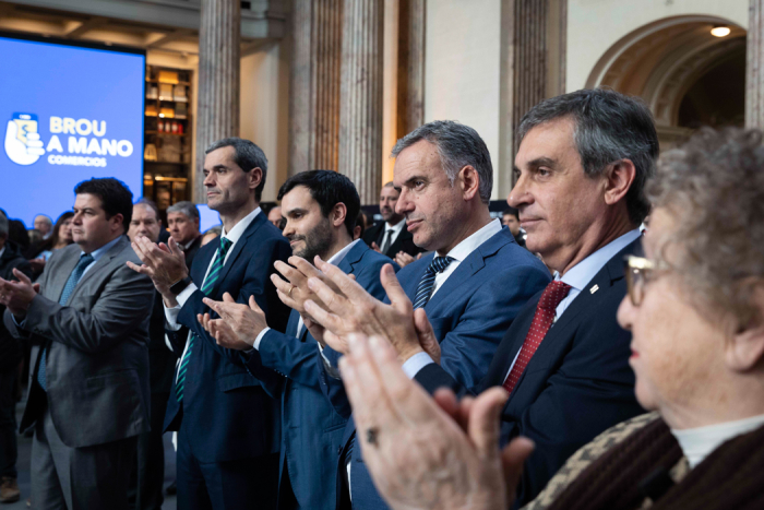 Presidente Yamandú Orsi aplaudiendo junto al presidente del Banco República, Álvaro García y otros participantes del evento