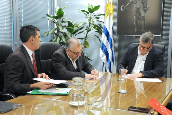 Autoridades de ambos organismos firmando el documento del acuerdo