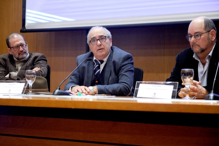 Fratti sentado tras mesa de oradores en conferencia de prensa
